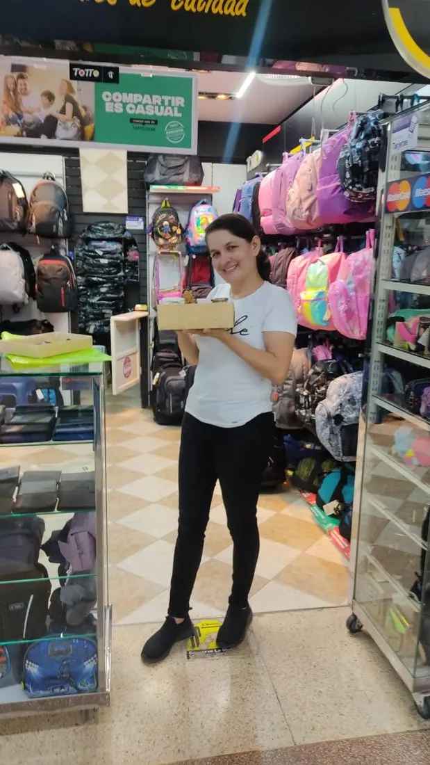 Integrante del equipo con una caja de pedido en el local